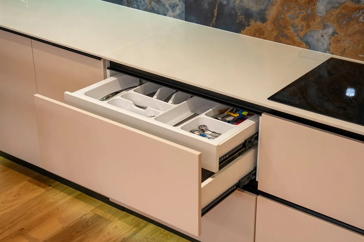An open kitchen drawer with organised cutlery