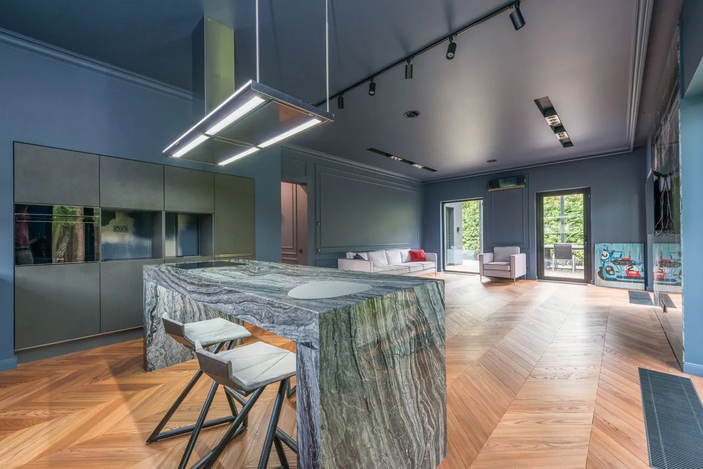 A stone-topped kitchen island with dark fronts